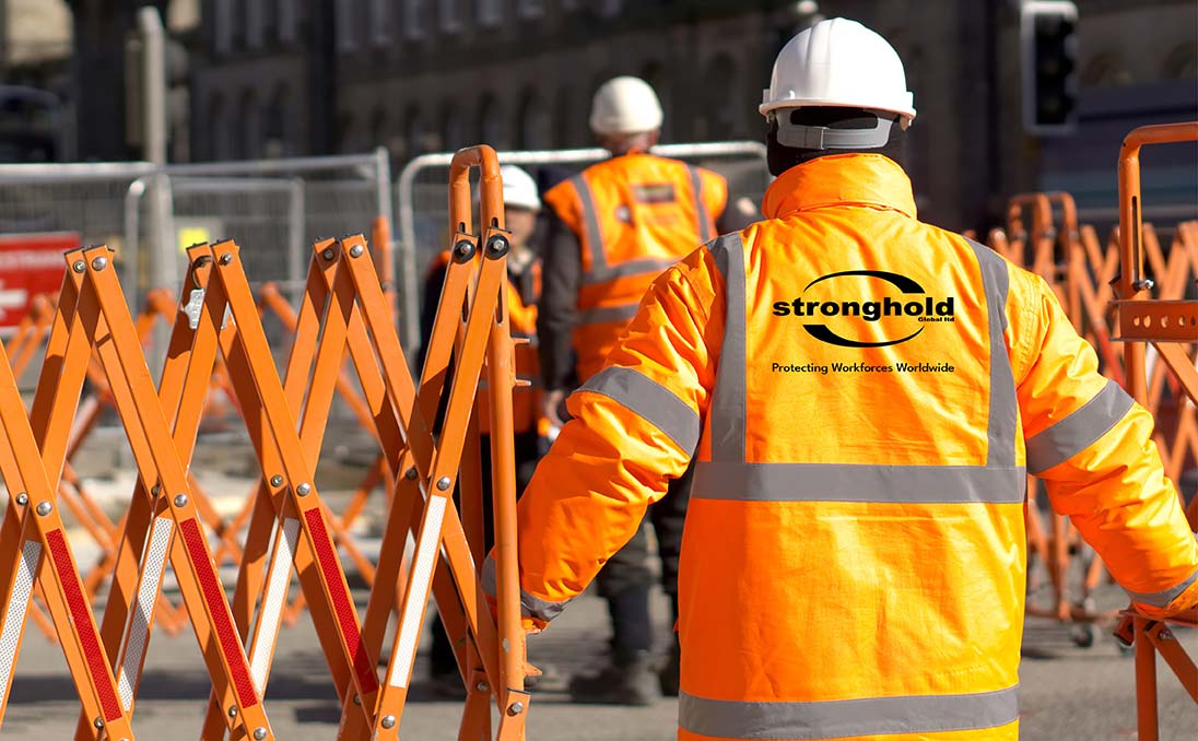 Man in a high visibility jacket with the Stronghold Global heat seal printed on the back