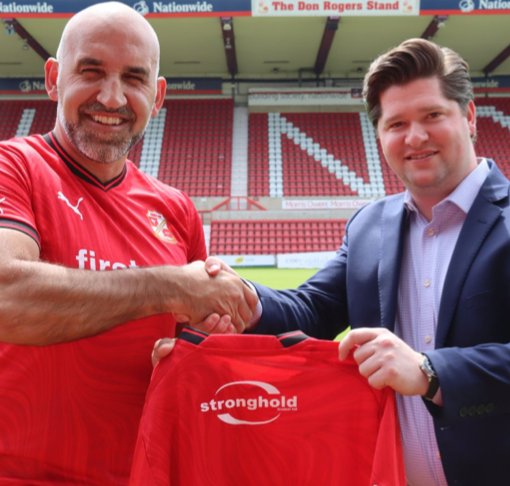 Swindon Town Football Club owner with Stronghold Global CEO holding team shirt with Stronghold Global Logo