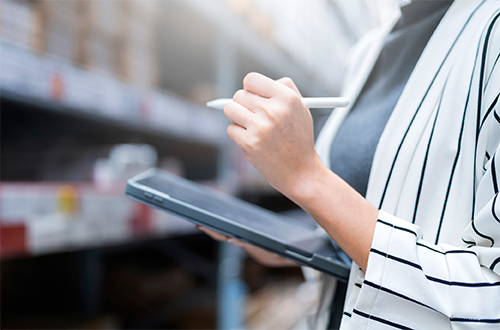 Woman with a tablet reviewing stocked shelves